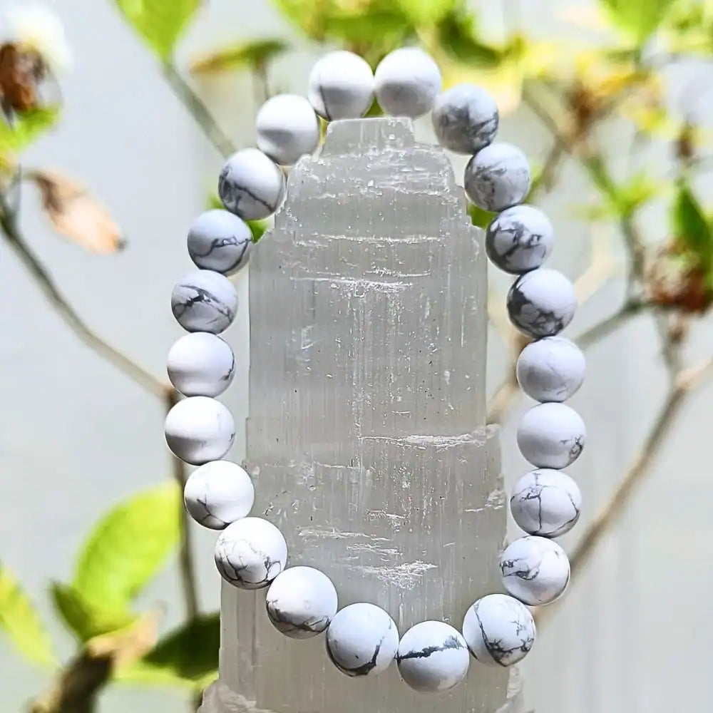 CRYSTCOP Howlite bracelet 8mm with white and gray marbled beads displayed on a clear crystal stand