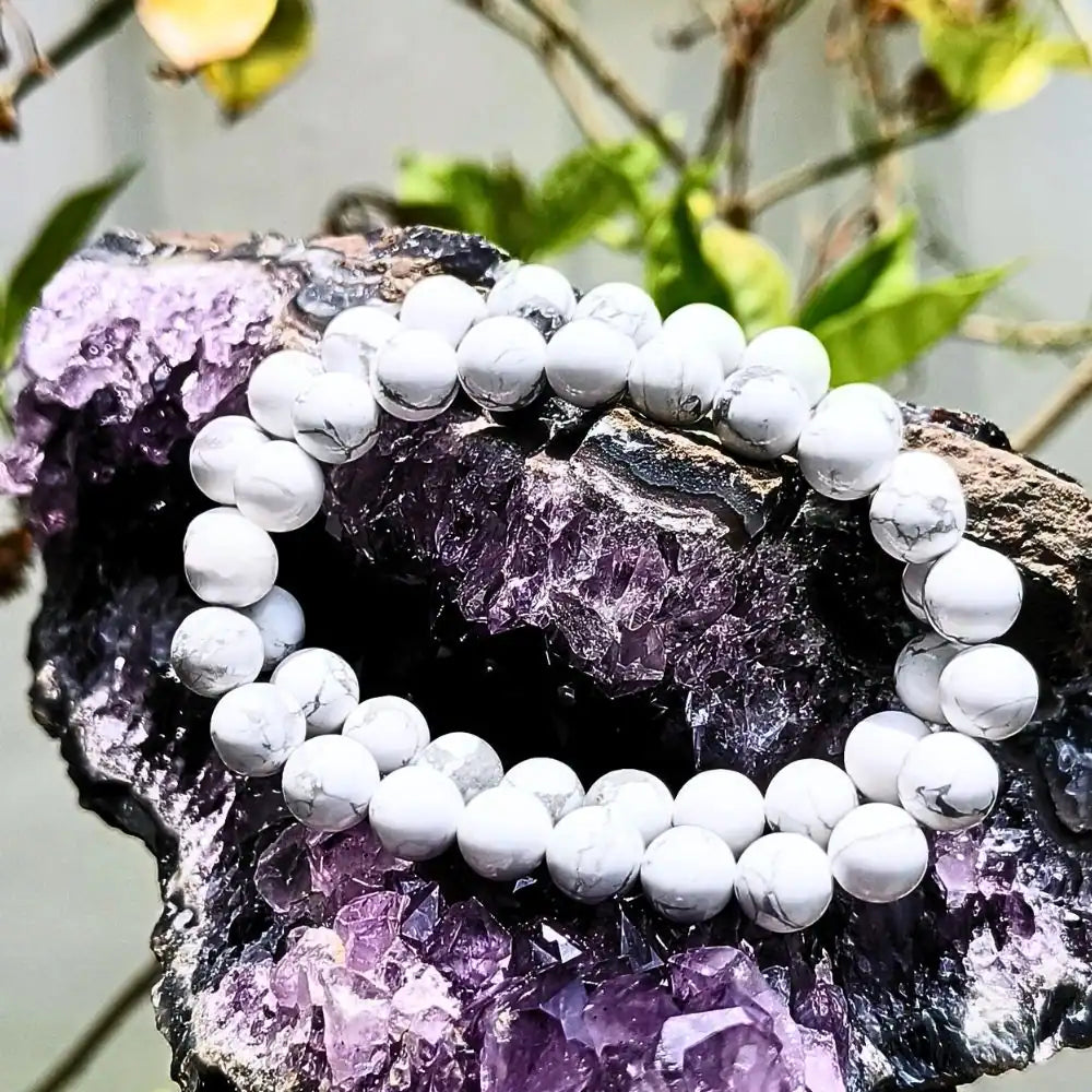 CRYSTCOP Howlite bracelet 8mm with white marbled beads displayed on purple crystal cluster