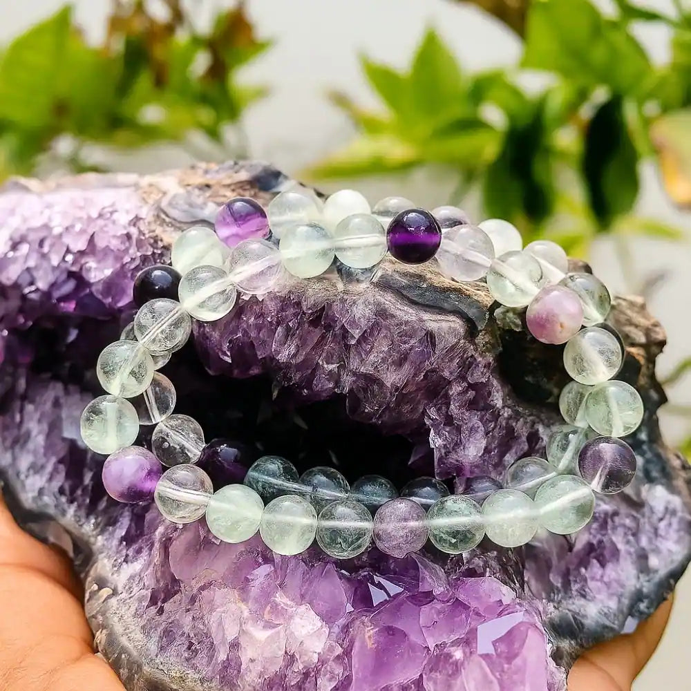 CRYSTCOP multi fluorite bracelet 8mm beads displayed on a purple amethyst crystal cluster