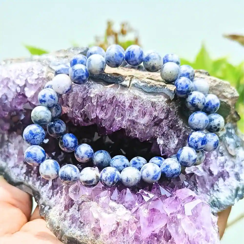 CRYSTCOP natural sodalite beaded bracelet with blue and white stones displayed on a purple crystal cluster