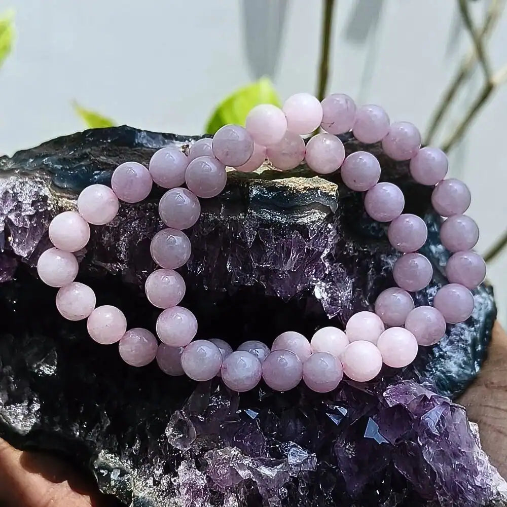 CRYSTCOP rose quartz energy jewelry pink beaded bracelets displayed on purple crystal cluster