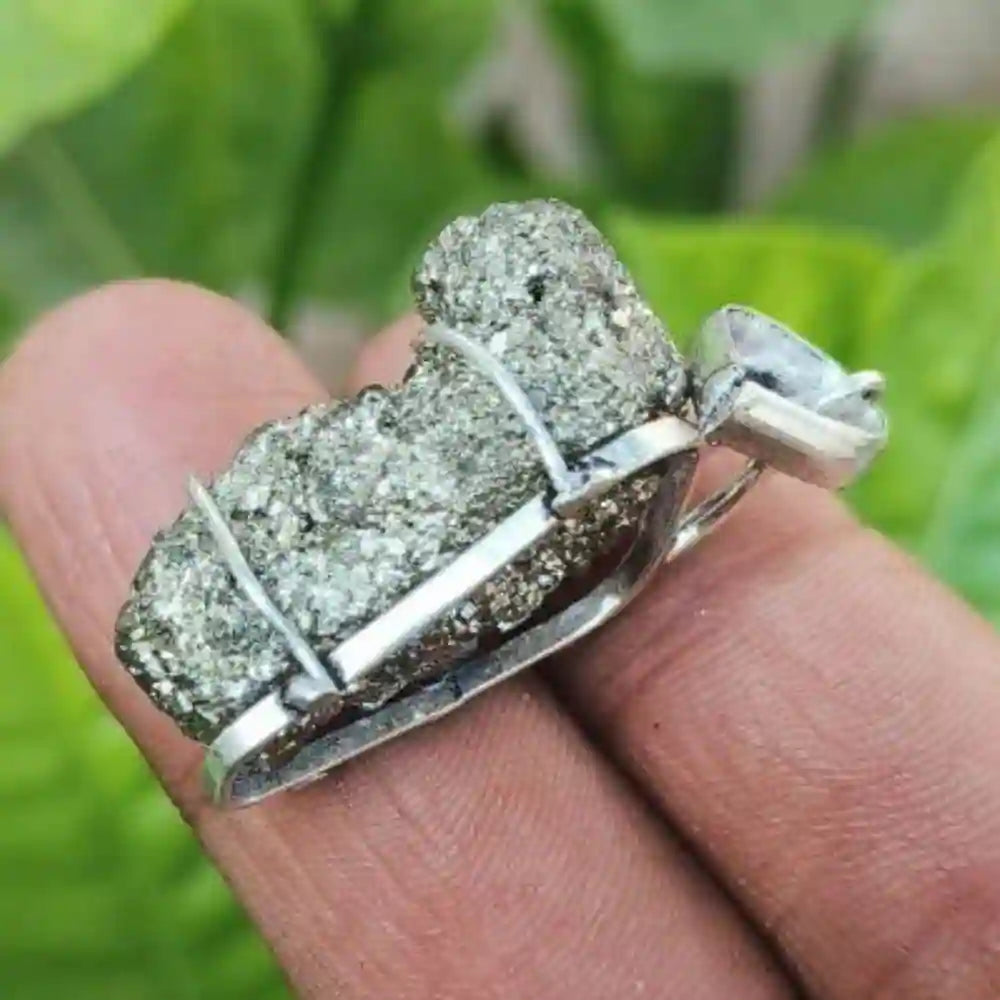 CRYSTCOP golden pyrite pendant held between fingers showing natural crystal texture