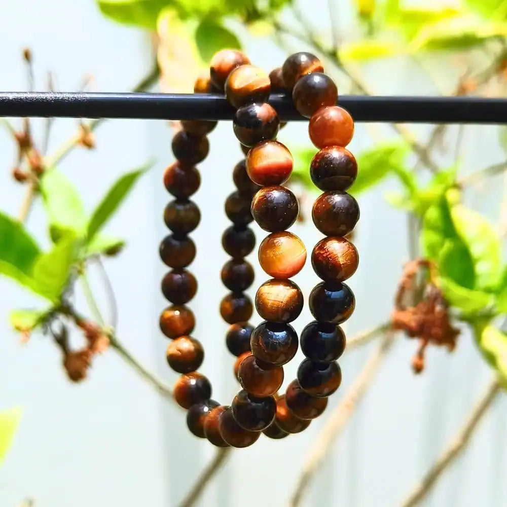 CRYSTCOP Tiger Eye bracelet 8mm featuring polished brown and golden beads on a black rod