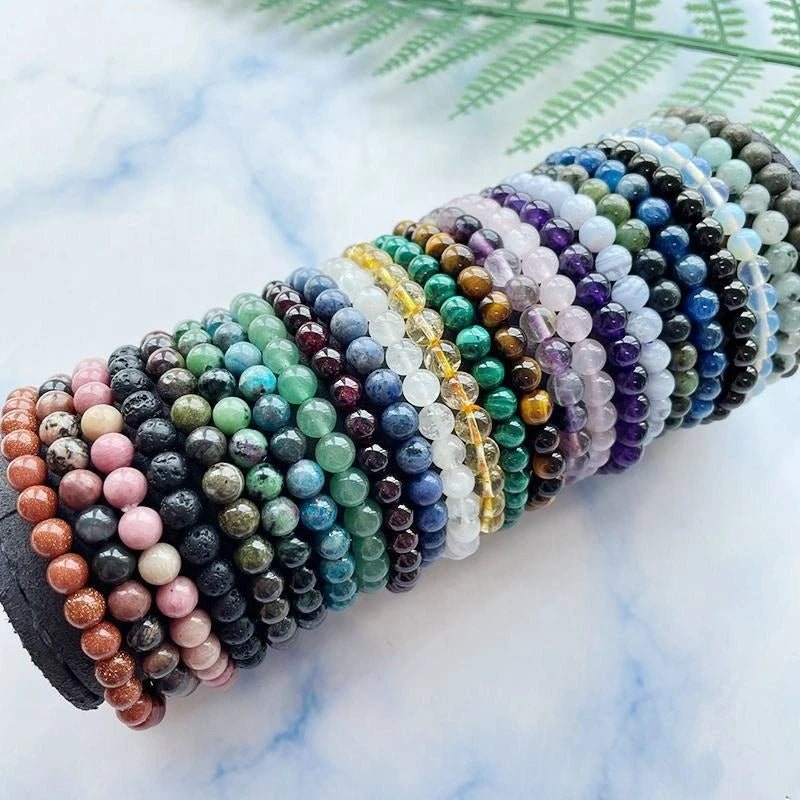 Colorful natural stone bracelets displayed in rows with various gemstone beads and patterns