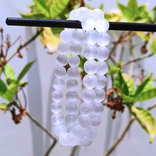 CRYSTCOP selenite bracelet 8mm with round translucent white beads hanging on a black rod