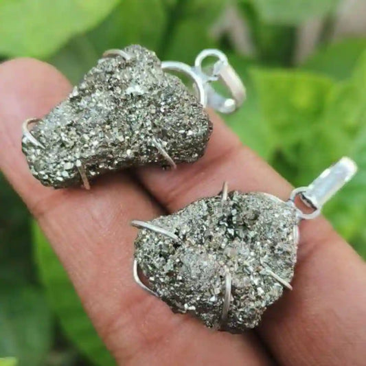 CRYSTCOP golden pyrite pendant with raw crystal texture and silver wire wrapping held on hand